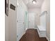 Hallway with wood floors, white trim, bench and three doors at 15211 Colonial Park Dr, Huntersville, NC 28078