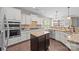 Kitchen with granite counters, stainless appliances, white cabinets, hardwood floors, and center island at 15211 Colonial Park Dr, Huntersville, NC 28078