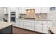 Kitchen featuring white cabinets, granite counters, stainless appliances, and hardwood floors at 15211 Colonial Park Dr, Huntersville, NC 28078
