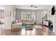 Inviting living room boasts hardwood floors, a comfortable sectional sofa and bright natural light at 15211 Colonial Park Dr, Huntersville, NC 28078