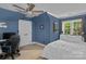 Comfortable bedroom with blue walls, ceiling fan, large closet, and window with backyard view at 18800 Boundary Oaks Ct, Davidson, NC 28036
