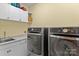 Well-organized laundry room with modern washer and dryer, sink, and ample cabinet space at 18800 Boundary Oaks Ct, Davidson, NC 28036