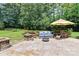 Outdoor patio with seating, a fire pit, and an umbrella for shade at 18800 Boundary Oaks Ct, Davidson, NC 28036