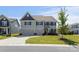 Inviting two-story home with a well-manicured lawn, a two car garage, and classic architectural details at 2097 Saddlebred Dr, Iron Station, NC 28080