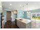 Open concept kitchen with stainless steel appliances, island with seating and a view to the backyard at 2097 Saddlebred Dr, Iron Station, NC 28080