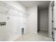 Functional laundry room with tile flooring, storage shelves, and connections for a washer and dryer at 2097 Saddlebred Dr, Iron Station, NC 28080