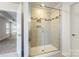 Elegant glass shower with tiled walls and built-in shelves, providing a spa-like experience at 2097 Saddlebred Dr, Iron Station, NC 28080