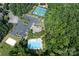 Aerial view of community pool, tennis courts, beach volleyball, and parking areas surrounded by mature trees at 221 N Centurion Ln, Mount Holly, NC 28120