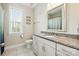 Well-lit bathroom featuring granite countertops, white cabinetry, and a large mirror above the sink at 221 N Centurion Ln, Mount Holly, NC 28120