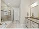 Bright bathroom with a glass-enclosed shower, soaking tub, granite counters, and white cabinets at 221 N Centurion Ln, Mount Holly, NC 28120