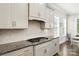 Kitchen detail featuring granite counters, stylish backsplash, and modern appliances at 221 N Centurion Ln, Mount Holly, NC 28120