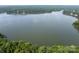 Scenic lake view surrounded by lush green trees, offering a serene and picturesque setting for lakeside living at 221 N Centurion Ln, Mount Holly, NC 28120