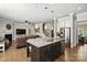 Open-concept living room, connecting seamlessly to the kitchen, with a fireplace and staircase at 221 N Centurion Ln, Mount Holly, NC 28120