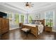 Bright main bedroom featuring tray ceilings, hardwood floors, and abundant natural light from many windows at 221 N Centurion Ln, Mount Holly, NC 28120