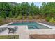 Backyard pool area with stone accents, a tanning deck, and lush landscaping at 221 N Centurion Ln, Mount Holly, NC 28120
