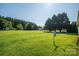 Large backyard with lush greenery, a shed, and wooded area at 2694 Rock Dam Rd, Lincolnton, NC 28092
