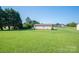 Expansive green backyard featuring the house and a backdrop of mature trees at 2694 Rock Dam Rd, Lincolnton, NC 28092