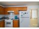 Practical kitchen with oak cabinetry, white appliances, and a view to a side door for easy access at 2694 Rock Dam Rd, Lincolnton, NC 28092