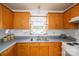 Functional kitchen featuring oak cabinets, a double sink beneath a window, and standard appliances for convenient meal preparation at 2694 Rock Dam Rd, Lincolnton, NC 28092