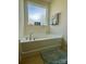 Relaxing bathroom featuring a soaking tub, neutral decor, and a frosted window at 2769 Sawbridge Ln, Gastonia, NC 28056