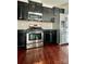 Modern kitchen with stainless steel appliances, black cabinetry, and hardwood floors at 2769 Sawbridge Ln, Gastonia, NC 28056