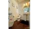 Stylish powder room featuring pedestal sink, wood floors, and decorative artwork at 2769 Sawbridge Ln, Gastonia, NC 28056