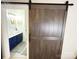 Bathroom entrance with a sliding barn door, featuring modern vanities and stylish decor at 3114 Luke Crossing Dr, Charlotte, NC 28226