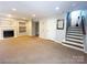 Spacious carpeted living room featuring a fireplace and stairs leading up to the next level at 3114 Luke Crossing Dr, Charlotte, NC 28226