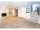 Open-concept living room with fireplace, lots of natural light, neutral paint, and staircase access at 3114 Luke Crossing Dr, Charlotte, NC 28226