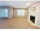 Cozy living room with a fireplace, built-in shelving, and large windows for plenty of natural light at 3114 Luke Crossing Dr, Charlotte, NC 28226