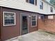 Exterior shot of a home backyard with a back door, red brick, and concrete at 4754 Old Lantern Way, Charlotte, NC 28212