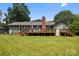 Expansive back yard with a beautiful deck, chimney, and green lawn perfect for outdoor entertaining at 5006 Crooked Oak Ln, Charlotte, NC 28226