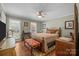 Bright bedroom with hardwood floors, ceiling fan, and plenty of natural light from large windows at 5006 Crooked Oak Ln, Charlotte, NC 28226
