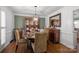 Cozy dining room featuring a round table with comfortable chairs, a china cabinet, and hardwood floors, exuding warmth at 5006 Crooked Oak Ln, Charlotte, NC 28226