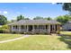 Charming single-story brick home featuring a welcoming front porch with decorative railings and a well-manicured lawn at 5006 Crooked Oak Ln, Charlotte, NC 28226