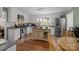 Open kitchen features white cabinets, an island, stainless steel appliances, and a view of the backyard at 5006 Crooked Oak Ln, Charlotte, NC 28226