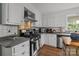 Well-lit kitchen features white cabinets, stainless steel appliances, brick backsplash, and durable countertops at 5006 Crooked Oak Ln, Charlotte, NC 28226