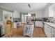 Bright kitchen featuring white cabinetry, a butcher block island, stainless steel appliances, and a view into the living area at 5006 Crooked Oak Ln, Charlotte, NC 28226