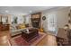 Cozy living room features a brick fireplace, hardwood floors, and ample natural light at 5006 Crooked Oak Ln, Charlotte, NC 28226