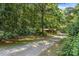The gravel driveway stretches back to the house surrounded by green trees and mature landscaping at 5212 Timber Creek Ct, Kings Mountain, NC 28086