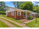 Charming brick house with a well-manicured lawn, inviting front porch, and tree lined yard at 564 Greenway Dr, Statesville, NC 28677