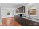 Modern kitchen with dark wood cabinets, stainless steel appliances, and hardwood floors at 564 Greenway Dr, Statesville, NC 28677