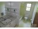 Functional bathroom with open shelves, shower/tub combination, and single sink vanity at 5823 Rupert Ln, Charlotte, NC 28215