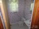 Compact bathroom with a toilet, sink, window, and floral wallpaper at 5823 Rupert Ln, Charlotte, NC 28215