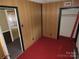 Bedroom with red carpet, wood paneled walls, and closet at 5823 Rupert Ln, Charlotte, NC 28215