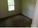 Empty bedroom with carpeting, baseboard heat, and a window for natural light at 5823 Rupert Ln, Charlotte, NC 28215