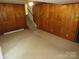 Retro paneled living room with adjacent stairway at 5823 Rupert Ln, Charlotte, NC 28215