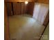 Spacious living room with hardwood paneled walls, and large windows providing ample light at 5823 Rupert Ln, Charlotte, NC 28215