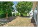 A tranquil backyard setting with mature trees, a well-kept lawn, and a cozy patio area at 7406 Carolina Jessamine Ct, Indian Land, SC 29707