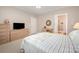 Bright bedroom featuring a ceiling fan, TV, wooden dresser, and ensuite bathroom at 7406 Carolina Jessamine Ct, Indian Land, SC 29707